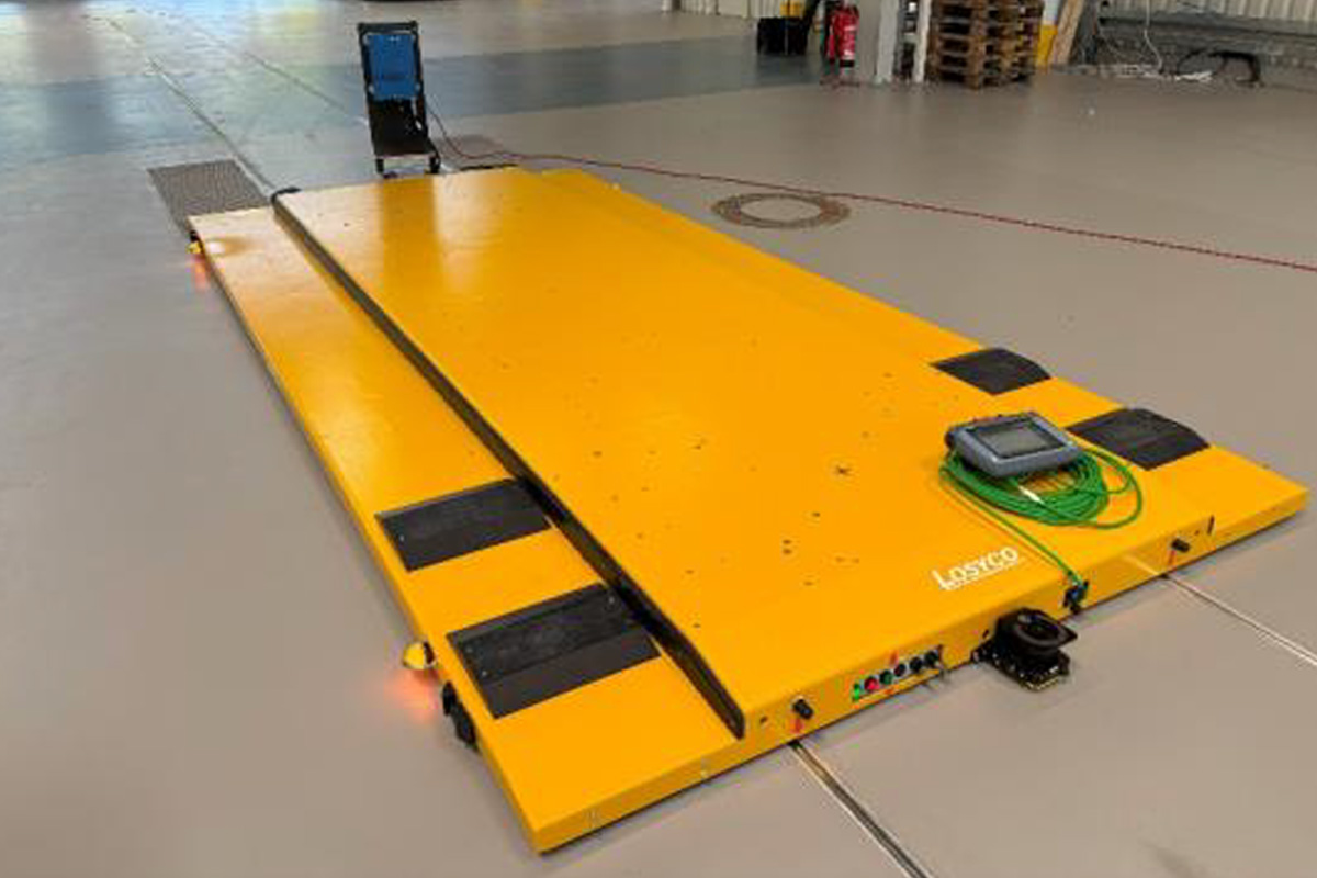 Große gelbe Plattformwaage mit elektronischem Bedienfeld auf einer industriellen Bodenfläche.