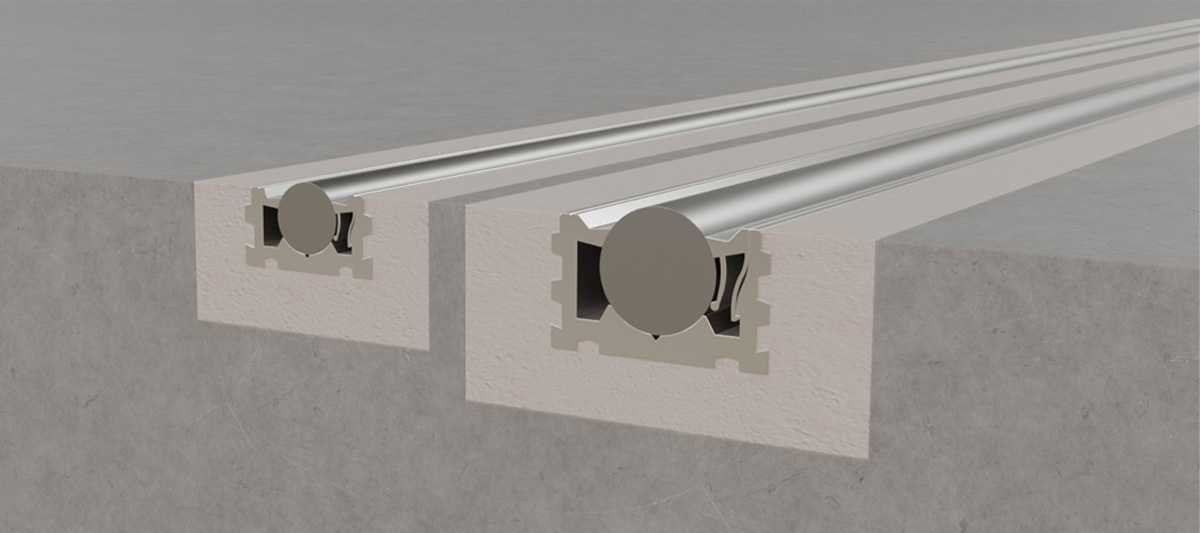Querschnitt zweier eingelassener Schienen in einem Betonboden, die Metallstäbe halten.